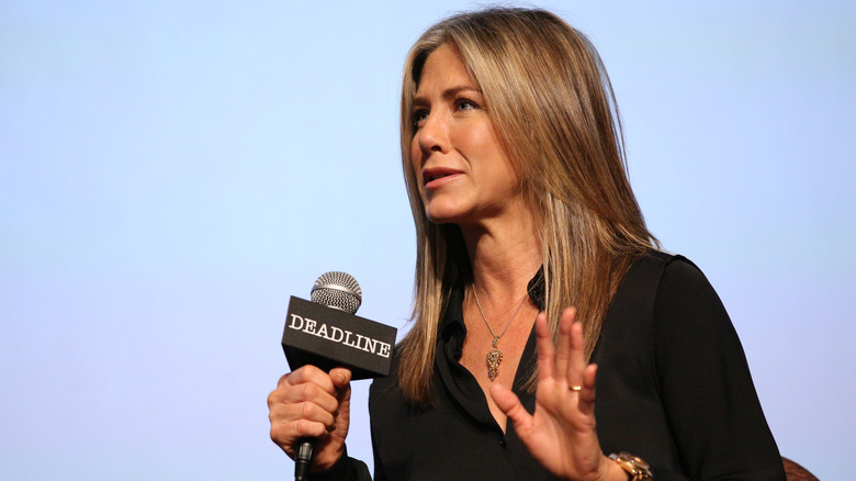 Jennifer Aniston speaking into a microphone