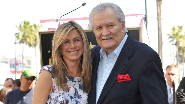 Jennifer Aniston in a floral dress beside father John Aniston