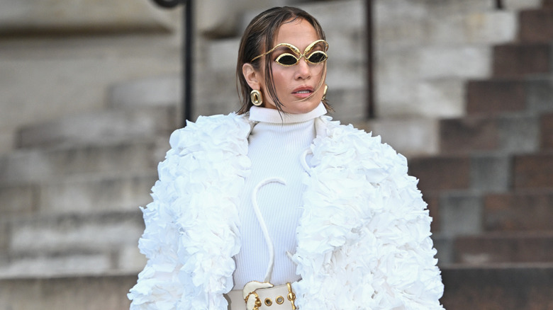 Jennifer Lopez smouldering in ornate sunglasses and a billowy white jacket