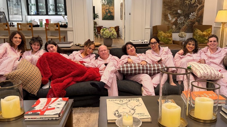 Jennifer Lopez sitting on a couch with family and friends in matching pjs