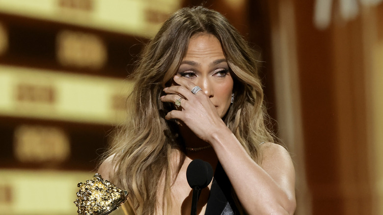 Jennifer Lopez wiping her eye on stage at the MTV Movie and TV Awards in 2022