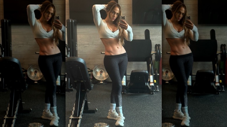 Jennifer Lopez showing off her abs in a mirror selfie in a gym