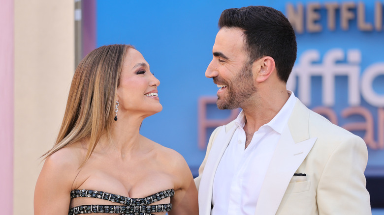 Jennifer Lopez and Brett Goldstein looking at each other at a press event for Office Romance