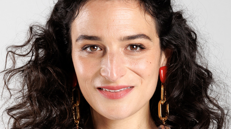 Jenny Slate smiling with chain earrings