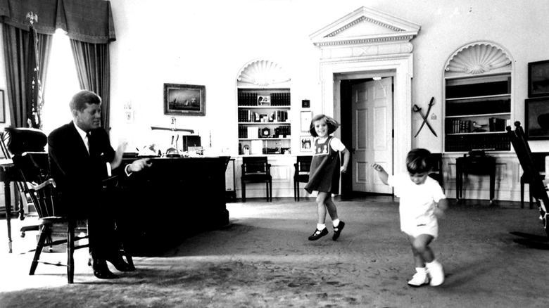 John F. Kennedy in the Oval Office playing with John F. Kennedy Jr. and Caroline Kennedy