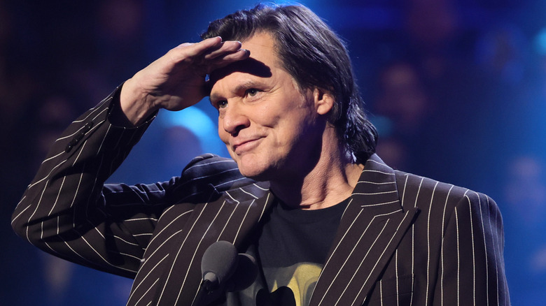 Jim Carrey putting his right hand on his forehead during an event