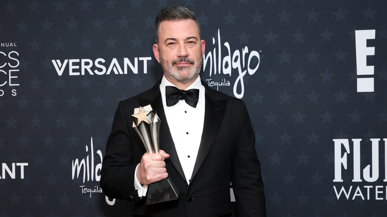 Jimmy Kimmel holding his 2026 Critic's Choice Award