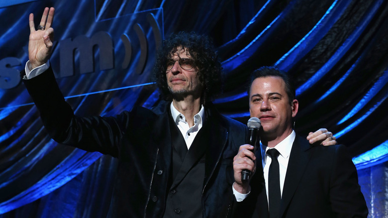 Howard Stern standing with his arm around Jimmy Kimmel onstage