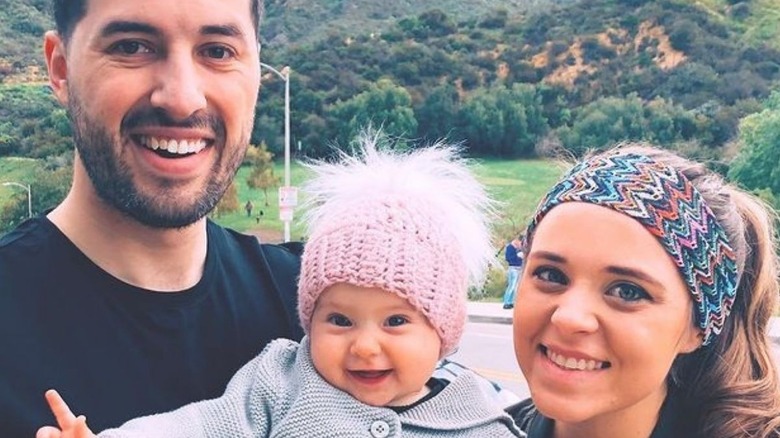 Jeremy Vuolo and Jinger Duggar smiling with baby