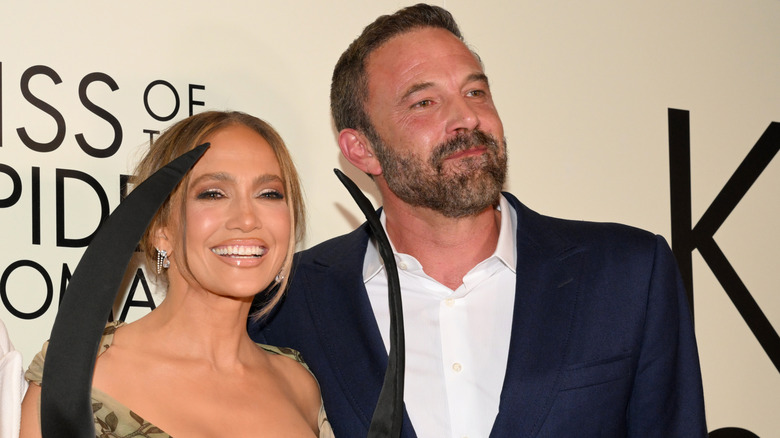 Ben Affleck and Jennifer Lopez smiling while posing on the red carpet together