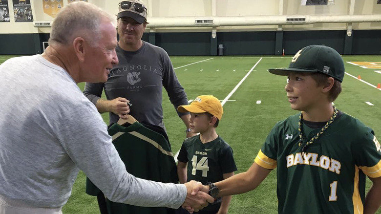 Drake Gaines shaking hands on a football field