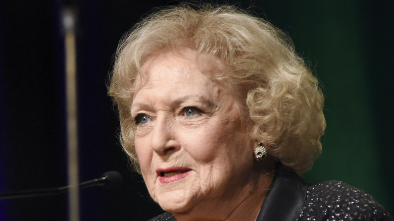 Betty White speaking wearing a black sparkly top