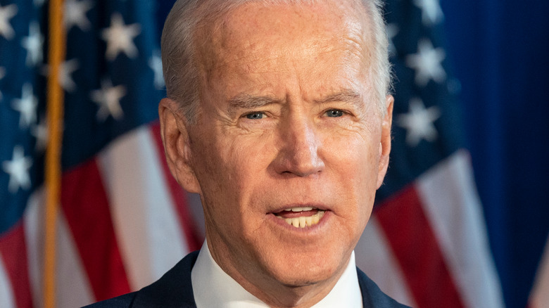 President Biden stands in front of American flag