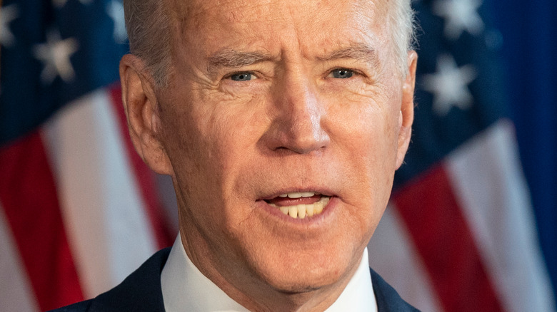 President Biden giving a speech in front of the American flag