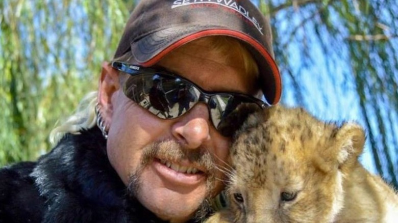 Joe Exotic poses with a baby tiger