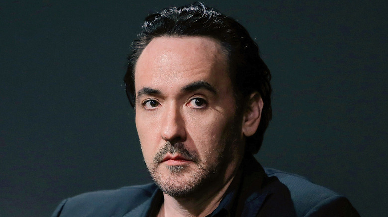 Straight-faced John Cusack looking away from the camera