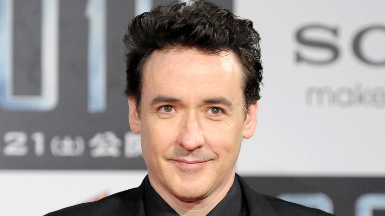 John Cusack smiling on the red carpet