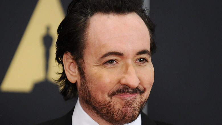 John Cusack smiling on the red carpet