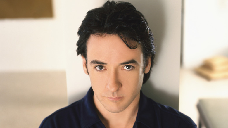 Young John Cusack posing for a photo
