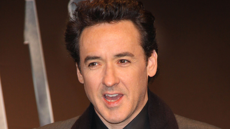 John Cusack speaking while snapping a photo