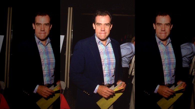 John Schuck pictured wearing a plaid shirt and blazer in the 1980s