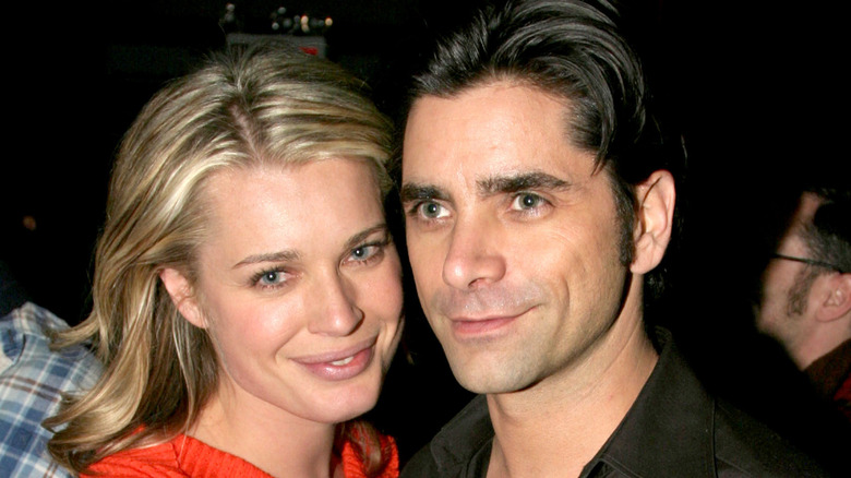 John Stamos and Rebecca Romijn embrace on the red carpet