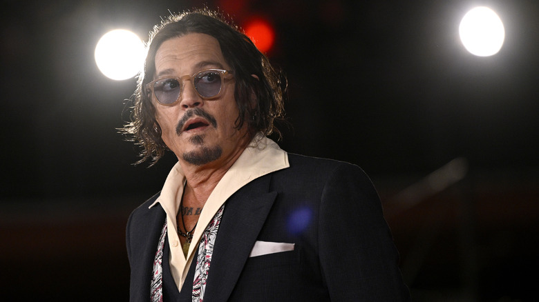Johnny Depp looking shocked off to the side in a suit