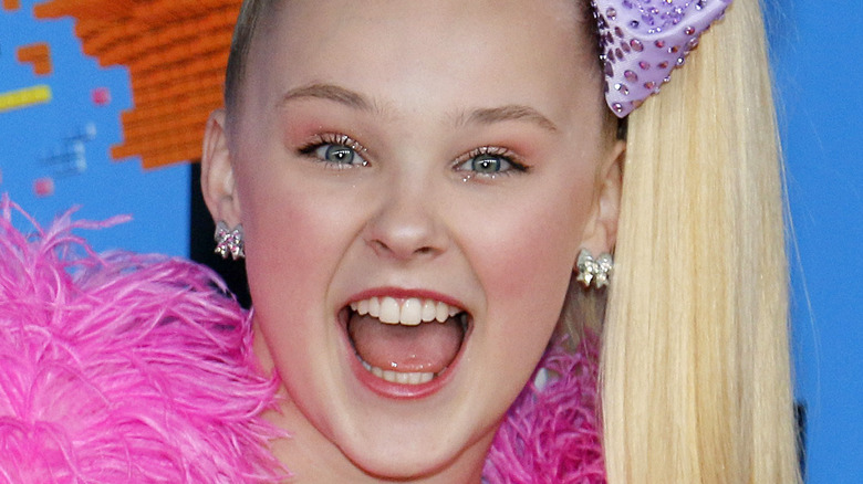 Jojo Siwa wearing a purple bow on the red carpet for Nickelodeon event