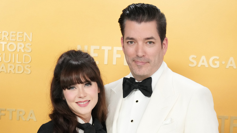 Zooey Deschanel and Jonathan Scott posing together in black and white formal wear