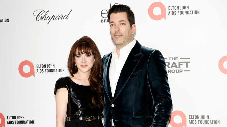 Zooey Deschanel and Jonathan Scott posing in front of a white backdrop