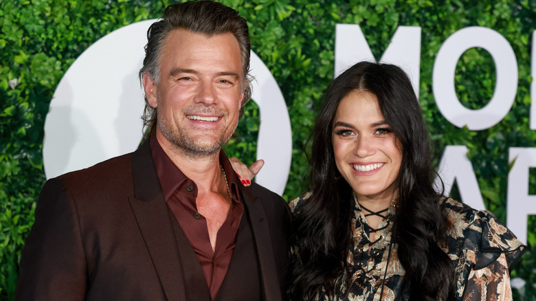 Josh Duhamel and Audra Mari smiling while posing at an event