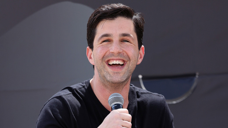 Peck smiling holding microphone