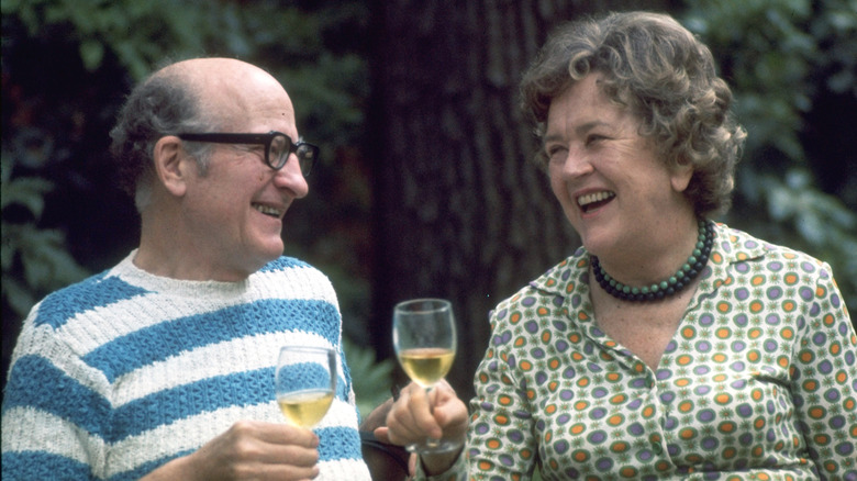 Julia Child and Paul Child holding glasses of wine and smiling
