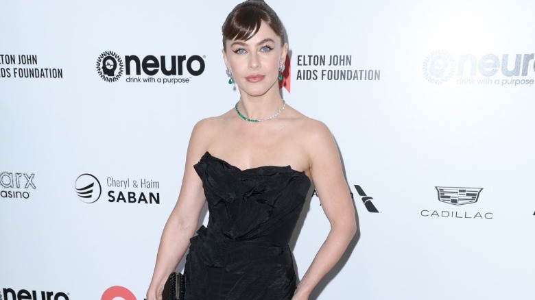 Julianne Hough with brunette hair and baby bangs and wearing a black strapless gown