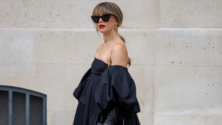 Julianne Hough walking the streets of Paris in a black minidress, gloves, tights, and sunglasses