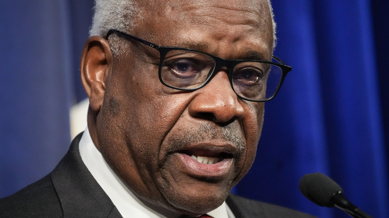  Justice Clarence Thomas speaks into microphone