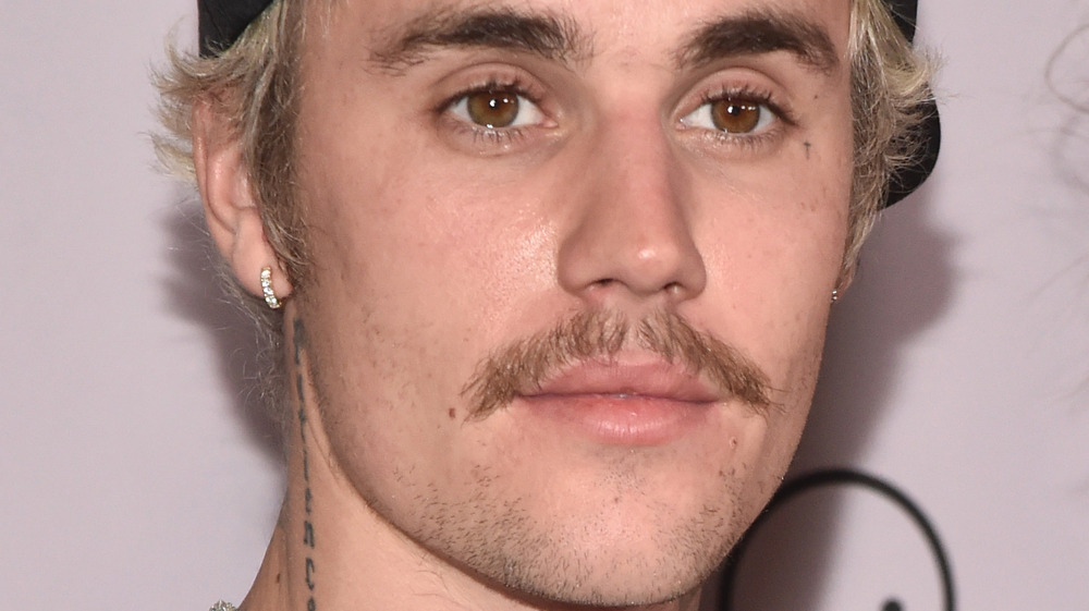 close up of Justin Bieber's face with neck tattoo