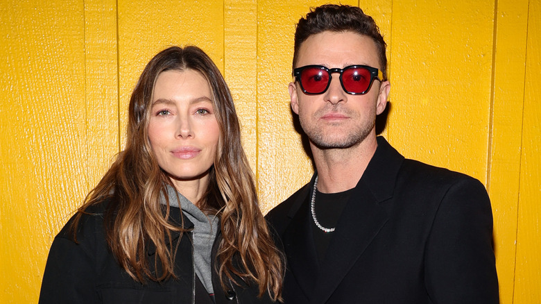 Jessica Biel and Justin Timberlake posing together in front of yellow wall