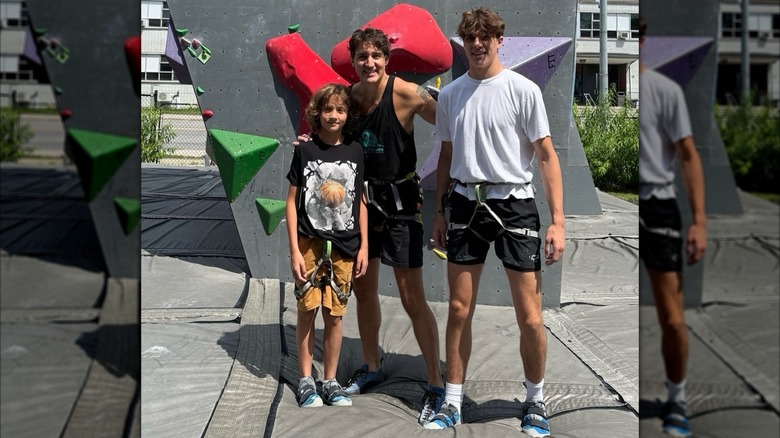 Justin, Hadrien, and Xavier Trudeau in front of rock climbing wall