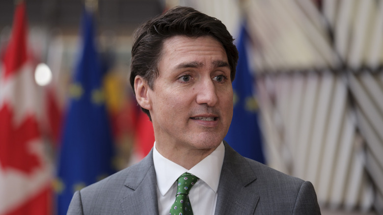 Justin Trudeau talking at an event while wearing a suit with a green tie