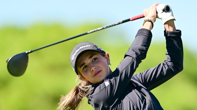 Kai Trump swinging a golf club