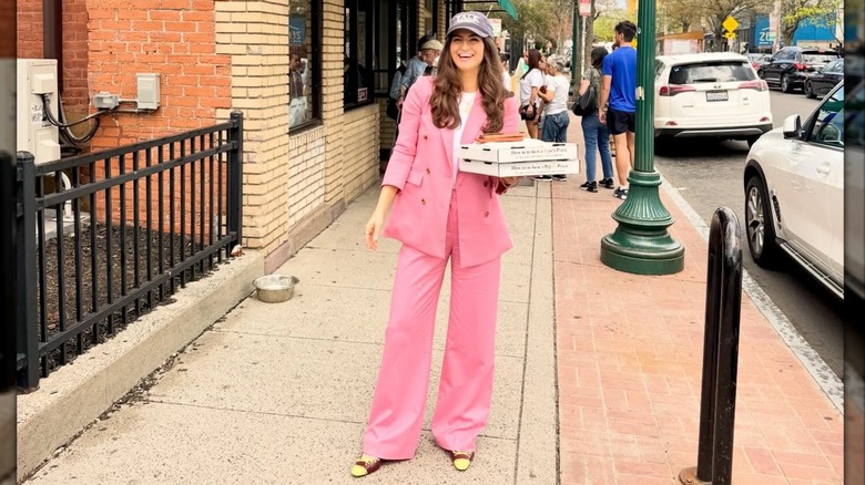 Kaitlan Collins smiling with pizzas