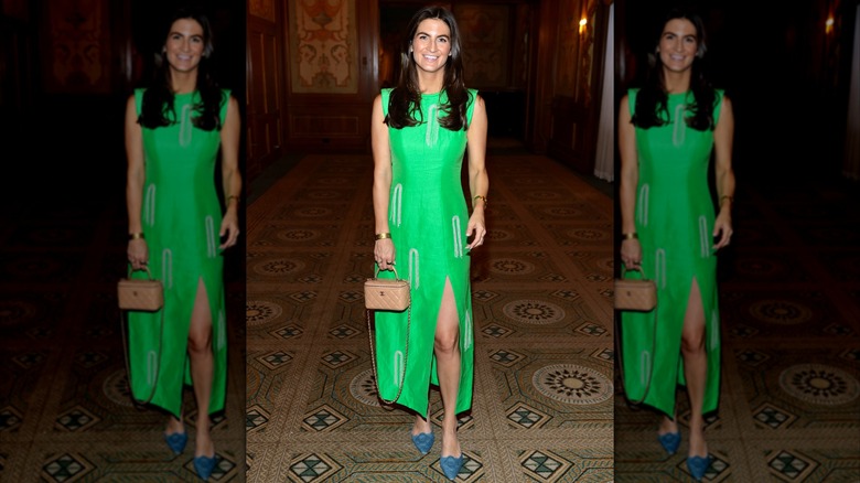 Kaitlan Collins smiling in a green gown and blue pointy-toed heels.