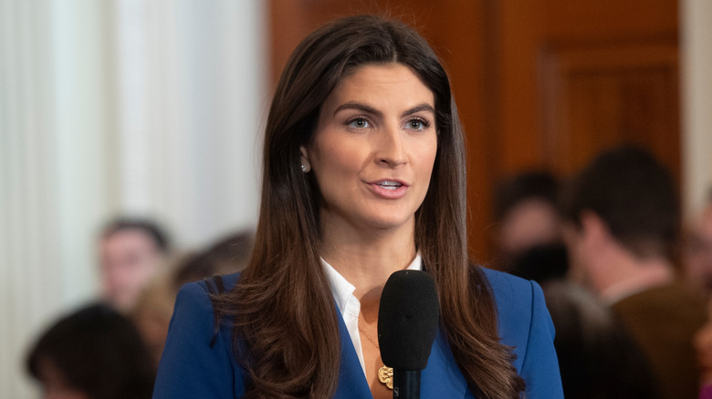 Kaitlan Collins wearing blue and speaking into a microphone