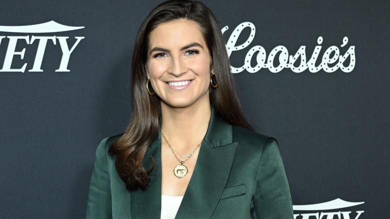 Kaitlan Collins smiling in a green blazer