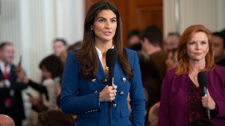 Kaitlan Collins at press conference holding mic