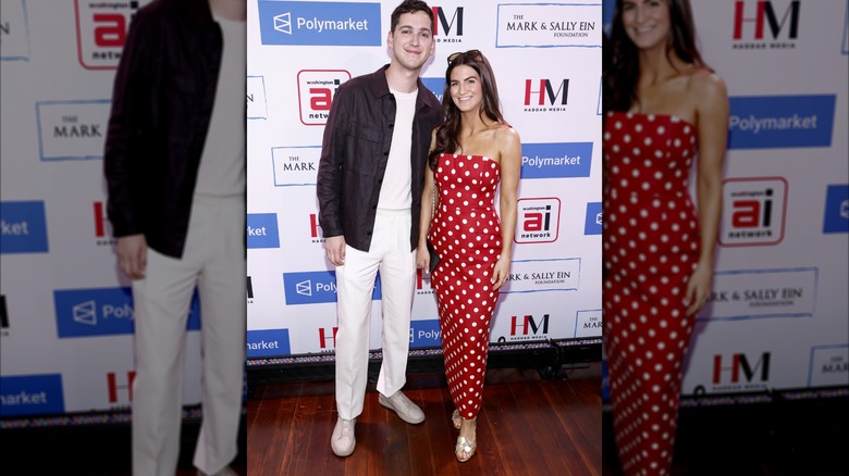 Kaitlan Collins smiling while wearing a red dress with white spots on it.