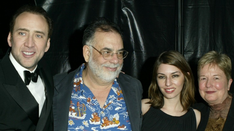 Nicolas Cage posing in a tuxedo with his famous Coppola relatives; Francis Ford Coppola, Sofia Coppola and Eleanor Coppola.