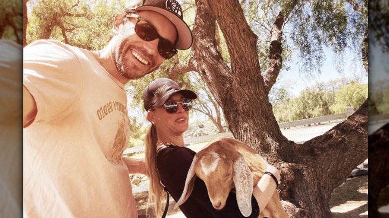 Kaley Cuoco and Tom Pelphrey posing with goat