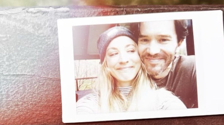 Polaroid of Kaley Cuoco and Tom Pelphrey smiling.